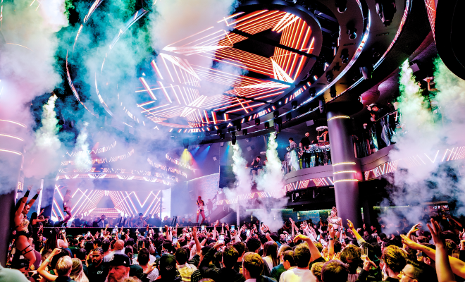 Crowd of people with fog machines fogging while celebrating in LIV nightclub