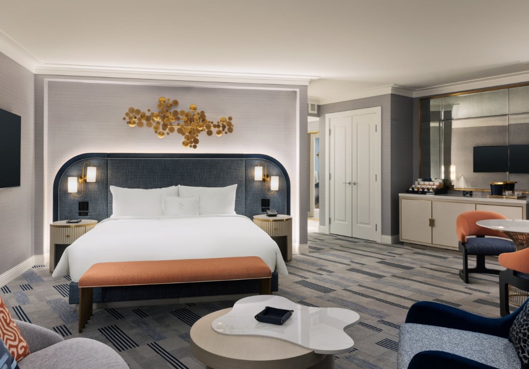 Bed and seating area underneath gold art piece